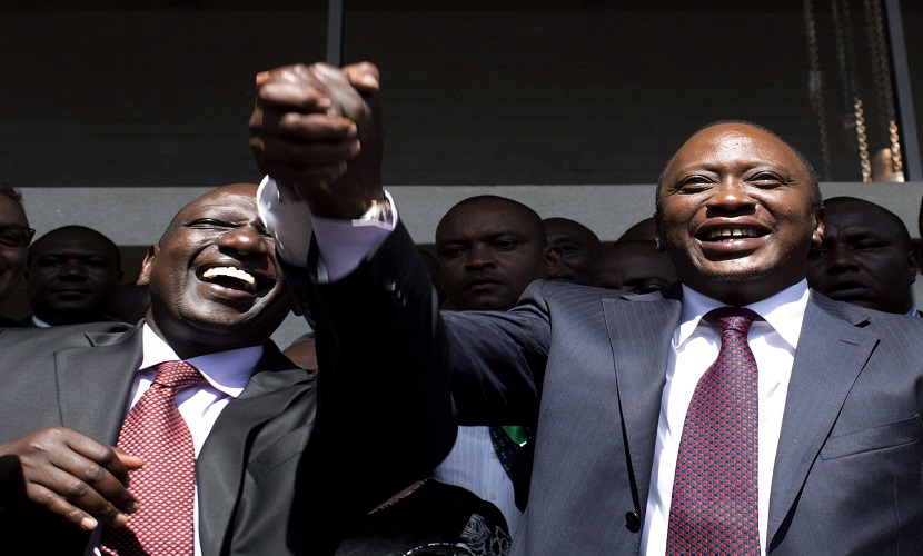 President-elect Uhuru Kenyatta (R) greets his supporters with his running mate, former cabinet minister William Ruto after attending a news conference in Nairobi March 9, 2013. Kenyatta, indicted for crimes against humanity, was declared winner of Kenya's presidential election on Saturday with a tiny margin, just enough to avoid a run-off after a race that has divided the nation along tribal lines. REUTERS/Siegfried Modola (KENYA - Tags: ELECTIONS POLITICS)